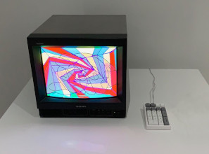 A modern Telidon display showing swirly red, magent, yellow and blue graphic, with a keypad sitting next to it